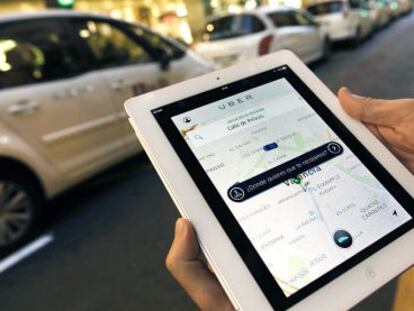 Un usuario de Uber consulta la aplicación en Valencia ante una parada de taxis.