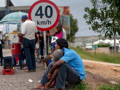 Refugiados venezuelanos formam fila em ponto de imigração brasileiro.