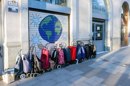 Carros de familias que acuden a recoger comida en una ONG del barrio de El Raval de Barcelona, en abril de 2021.