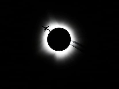 An airplane passes near the total solar eclipse during the Hoosier Cosmic Celebration at Memorial Stadium in Bloomington, Indiana, U.S. April 8, 2024. Bobby Goddin/USA Today Network via REUTERS NO RESALES. NO ARCHIVES. MANDATORY CREDIT     TPX IMAGES OF THE DAY