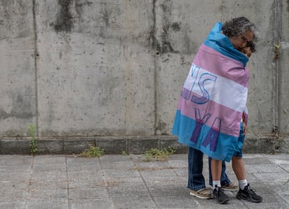 María José Rodríguez abraza a su hijo, Alejandro, de ocho años, envueltos en la bandera trans. EFE