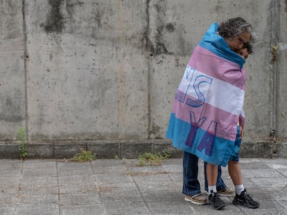 María José Rodríguez abraza a su hijo, Alejandro, de ocho años, envueltos en la bandera trans. EFE