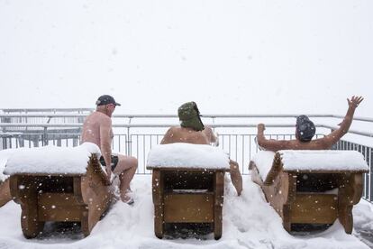 Andre, Markus y Mani conversan sentados en hamacas durante una nevada en la montaña de Stanserhorn, en el cantón de Nidwalden, ayer, 27 de abril de 2017.