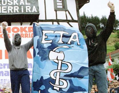 Simpatizantes del grupo terrorista ETA, con la cara cubierta, portan una bandera con el símbolo de ETA (el hacha y la serpiente) durante el funeral de la etarra Ignacia Ceberio, en la localidad de Lizarza, fallecida en un choque policial en Gernika (Vizcaya).