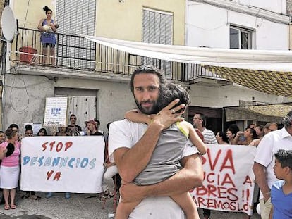Juan Manuel, el hombre que pretenden desahuciar, abrazado a su hijo.