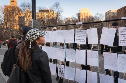 Visitantes de una exposición de The Strangers Project en Washington Square Park (Nueva York) en mayo leen mensajes dejados por algunos de los participantes.