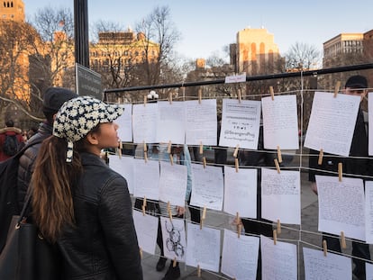 Visitantes de una exposición de The Strangers Project en Washington Square Park (Nueva York) en mayo leen mensajes dejados por algunos de los participantes.