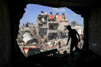 Un joven busca objetos entre los escombros de un edificio alcanzado por un bombardeo israelí, este miércoles en Jan Yunis.