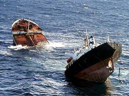 El petrolero <b></b><i>Prestige,</i> abierto por una de sus planchas y roto en dos, se hunde frente a las costas gallegas.