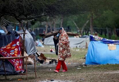 Ante la ola de frío, habitantes de ambos lados de la frontera se han acercado a los migrantes para obsequiarles ropa, leña o alguna bebida caliente. En la imagen, un migrante carga un trozo de madera para encender una fogata en un campamento en Matamoros, el 23 de diciembre de 2022.