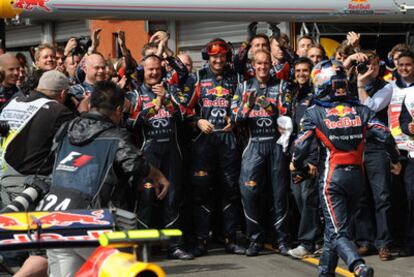 Vettel (a la derecha) acude a reunirse con los miembros de su equipo para celebrar el triunfo.