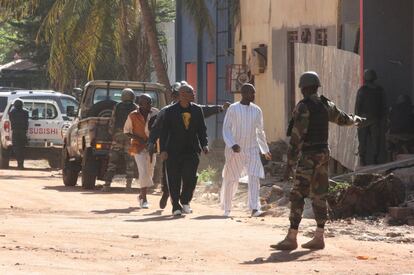 L'ambaixada d'Espanya a Mali ha informat que s'ha registrat una explosió i diversos trets. A la imatge, forces de seguretat escorten diverses persones a Bamako.