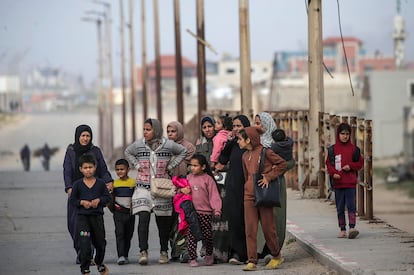 Palestinian women and children cross from the north to the south of Gaza along the Al Rashid highway, on the 21st.