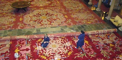 Dos operarias sustituyendo una alfombra original del Hotel de la Reconquista de Oviedo, por una r&eacute;plica exacta tambi&eacute;n realizada a mano por la Real F&aacute;brica. 