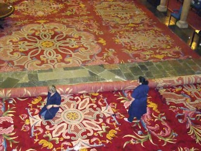 Dos operarias sustituyendo una alfombra original del Hotel de la Reconquista de Oviedo, por una r&eacute;plica exacta tambi&eacute;n realizada a mano por la Real F&aacute;brica. 