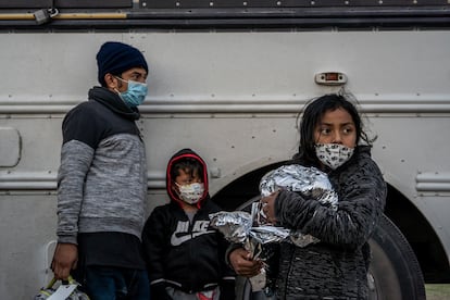 Alberto y su  hijo Dalton, de El Salvador, esperan al lado de María y su hija Diana, de Honduras, mientras se entregan a la patrulla fronteriza de EE UU, el pasado mes de abril.