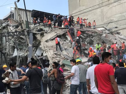 Voluntarios trabajan en las tareas de ayuda junto a un edificio derrumbado en Ciudad de México tras el terremoto que ha afectado al país.