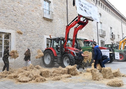 Agricultores protestan tirando paja ante la Delegación de la Generalitat en Girona, este martes.