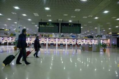 Two passengers walk through the ticketing area at the Reus airport in Tarragona.