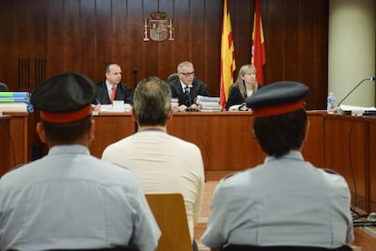 L'acusat, escortat per dos mossos, a la sala de vistes.