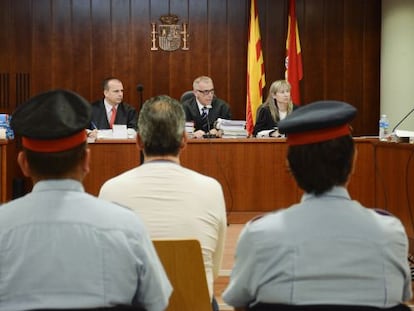 L'acusat, escortat per dos mossos, a la sala de vistes.