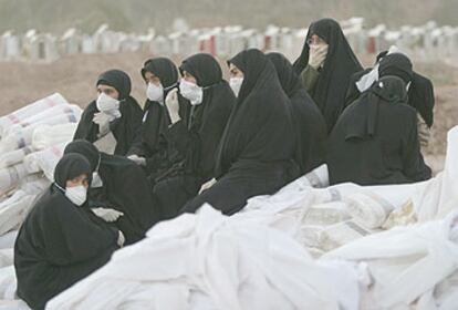 Un grupo de mujeres descansa tras un entierro masivo de víctimas del terremoto ayer en Bam.