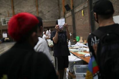 Un funcionario electoral muestra una papeleta durante el escrutinio posterior al cierre de la mesa electoral, en Santiago, Chile.