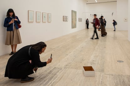 Visitantes observan la obra 'Caja vaca de zapatos'.