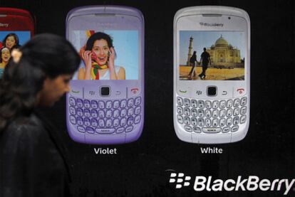 Una mujer pasea por las calles de Bombay ante un anuncio de Blackberry.