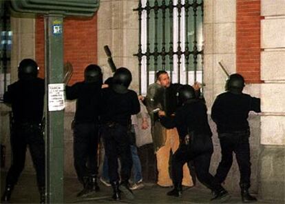 Varios policías cargan contra los manifestantes congregados en la Puerta del Sol de Madrid.