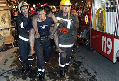 Los bomberos rescatan a los heridos del incendio de Taipei.