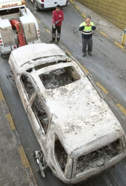 El todoterreno incendiado es sacado por una grúa del garaje.