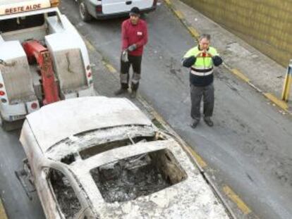 El todoterreno incendiado es sacado por una grúa del garaje.