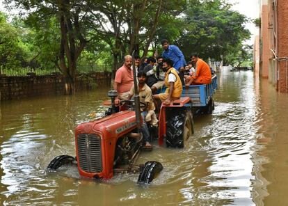 Los residentes son evacuados en un tractor después de que las fuertes lluvias causaron inundaciones en una zona residencial de Bangalore, la India.