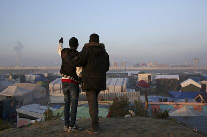 Dos personas observan las tiendas del campamento de Calais durante el segundo día de evacuación. 