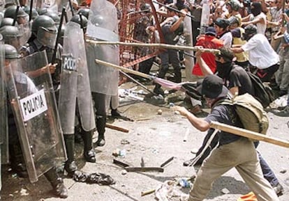 Varios manifestantes atacan con palos a la policía mexicana en una protesta contra la OMC en Cancún.