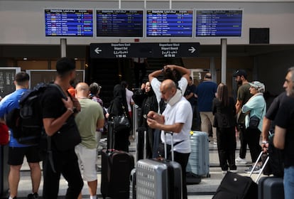 Many travellers consult information panels at Beirut airport this Sunday.