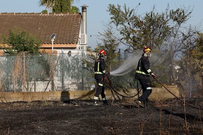 Los bomberos tratan de apagar este viernes los rescoldos del fuego en Navalcarnero.