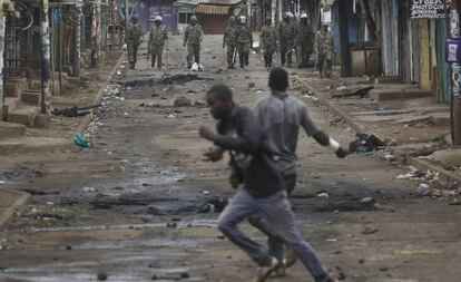 Dos partidarios del opositor Odinga se enfrentan a la Polic&iacute;a, este s&aacute;bado en un suburbio de Nairobi.