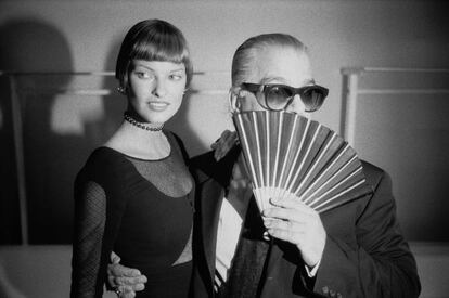 Karl Lagerfeld se oculta con un abanico mientras posa con la modelo Linda Evangelista.