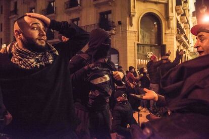 Un manifestante increpa a jóvenes infiltrados que lanzan bombas de sonido contra las fuerzas de seguridad para provocar enfrentamientos este sábado durante las protestas en Beirut.