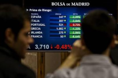 Dos agentes de bolsa delante de un panel con los valores de la Bolsa de Madrid. EFE/Archivo