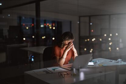 Una joven empresaria trabajando de noche en una oficina ya desierta.