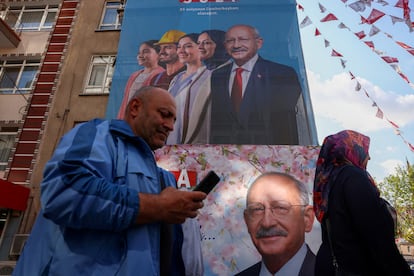 Un hombre pasa delante de una lona con la imagen del candidato conjunto de la oposición, Kemal Kilicdaroglu, antes de votar en Ankara, este domingo.