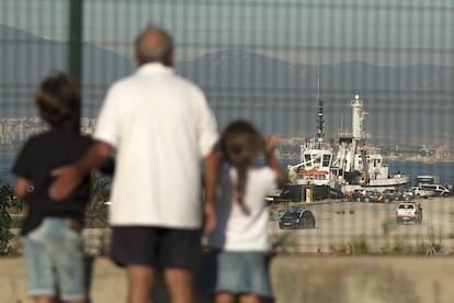 Un grupo de personas miran en la lejanía al buque Open Arms a su llegada al puertos e Algeciras tras rescatar a 87 migrantes en aguas de Libia.
