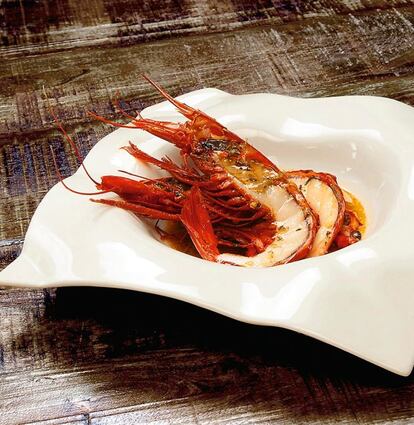 <b>Ingredientes: </b> 250 gramos de carabineros partidos por la mitad a lo largo, sal Maldon, 0,1 decilitros de salsa de soja, 1 cucharada de aceite de oliva, 5 gramos de jengibre fresco, 0,2 decilitros de agua y 0,2 decilitros de Mirim (condimento característico de la cocina japonesa). <p><b>Preparación</b>: 1. Partir los carabineros por la mitad a lo largo y disponerlos en una bandeja de horno con la carne hacia arriba. 3. Mezclar para la “sal” 15 gramos de té de Ceilán con 55 gramos de sal Maldon y 20 gramos de jengibre fresco rallado, sazonar con esta mezcla las gambas. 3. Añadir a la bandeja de las gambas una cucharada de salsa de soja, una de aceite de oliva virgen extra, dos de Mirim y dos de agua por cada carabinero grande y meter al horno a 250º C durante unos tres minutos. 4. Poner el caldito resultante en el fondo del plato. 5. Sacar y servir. <p>Parte de la sorpresa de este plato, además del sabor fusión que aportan algunos de los ingredientes, es el caldo que resulta de esta mezcla horneada. Puesta en el fondo del plato, crea una sopa estupenda, que hará las delicias de los comensales.