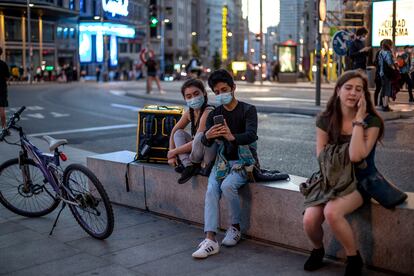 Varias personas utilizan el teléfono móvil por las calles de Madrid en septiembre.