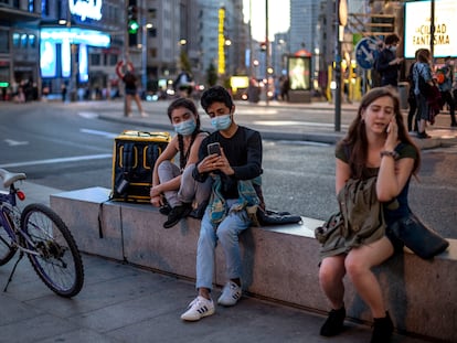 Varias personas utilizan el teléfono móvil por las calles de Madrid en septiembre.