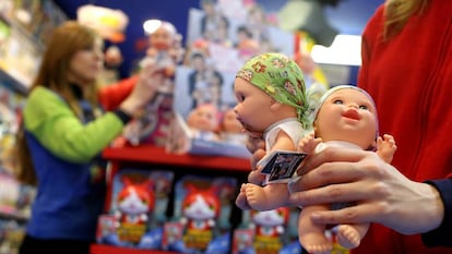 Una dependienta con dos mu&ntilde;ecos Baby Pelones en una tienda de Madrid.