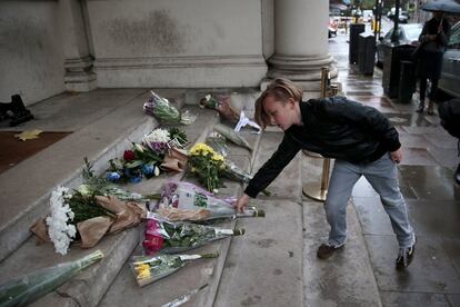 Un joven deja flores en homenaje a las víctimas de los ataques de París en la Embajada de Francia en Londres (Reino Unido).